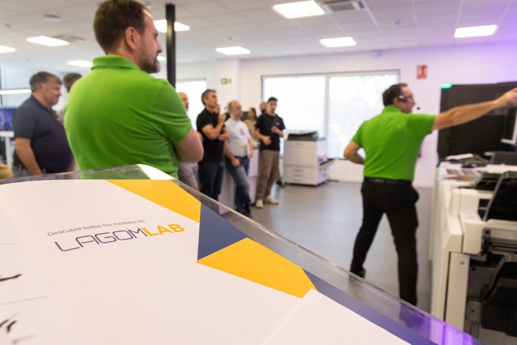 Programa de LagomLab sobre el atril del showroom con especialistas de Fujifilm al fondo